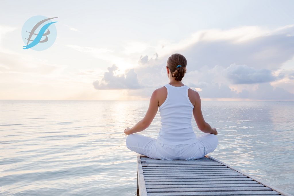 Caucasian woman practicing yoga at seashore